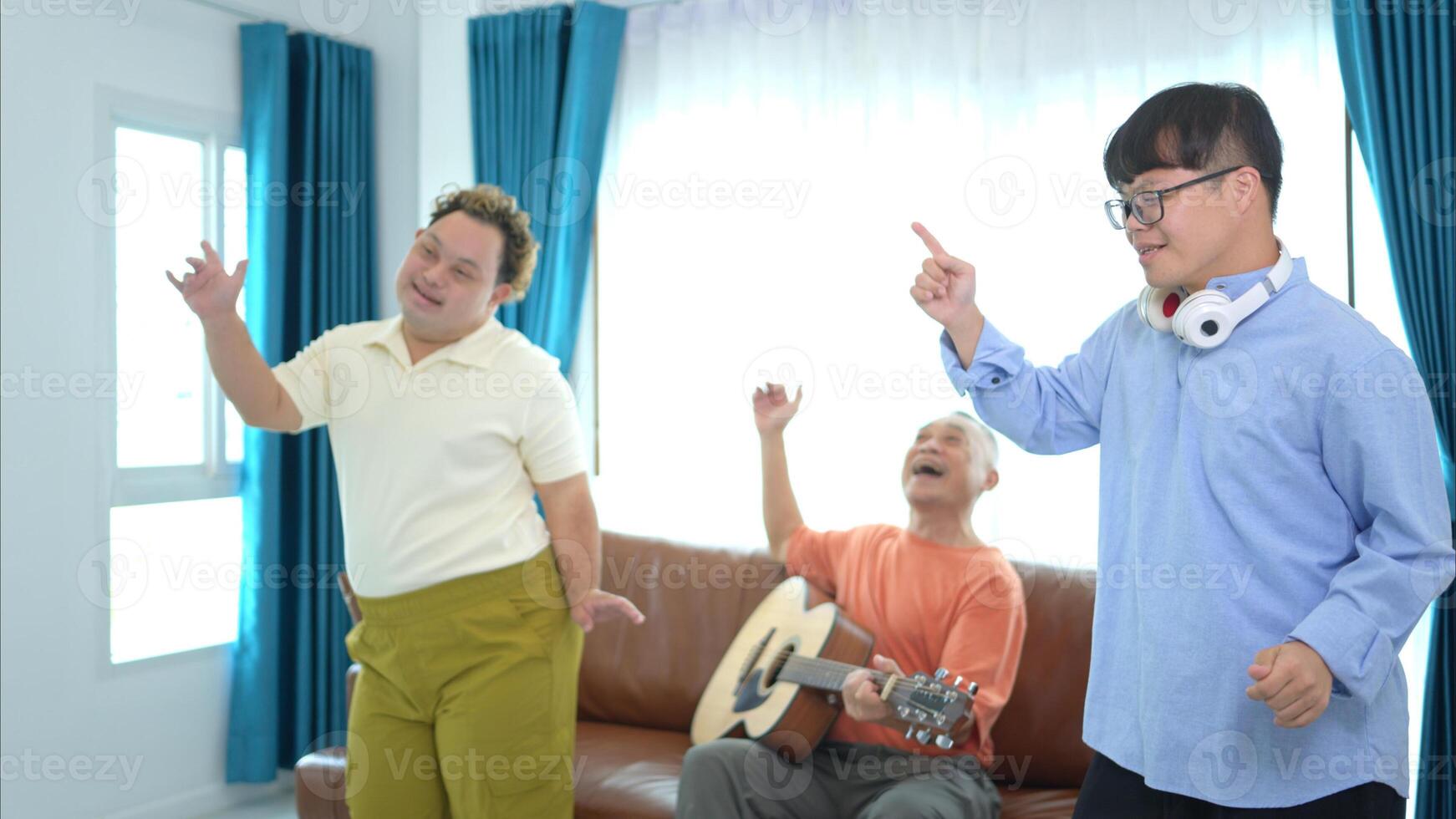 A family with an autistic child enjoys singing and dancing together at home during the holidays photo