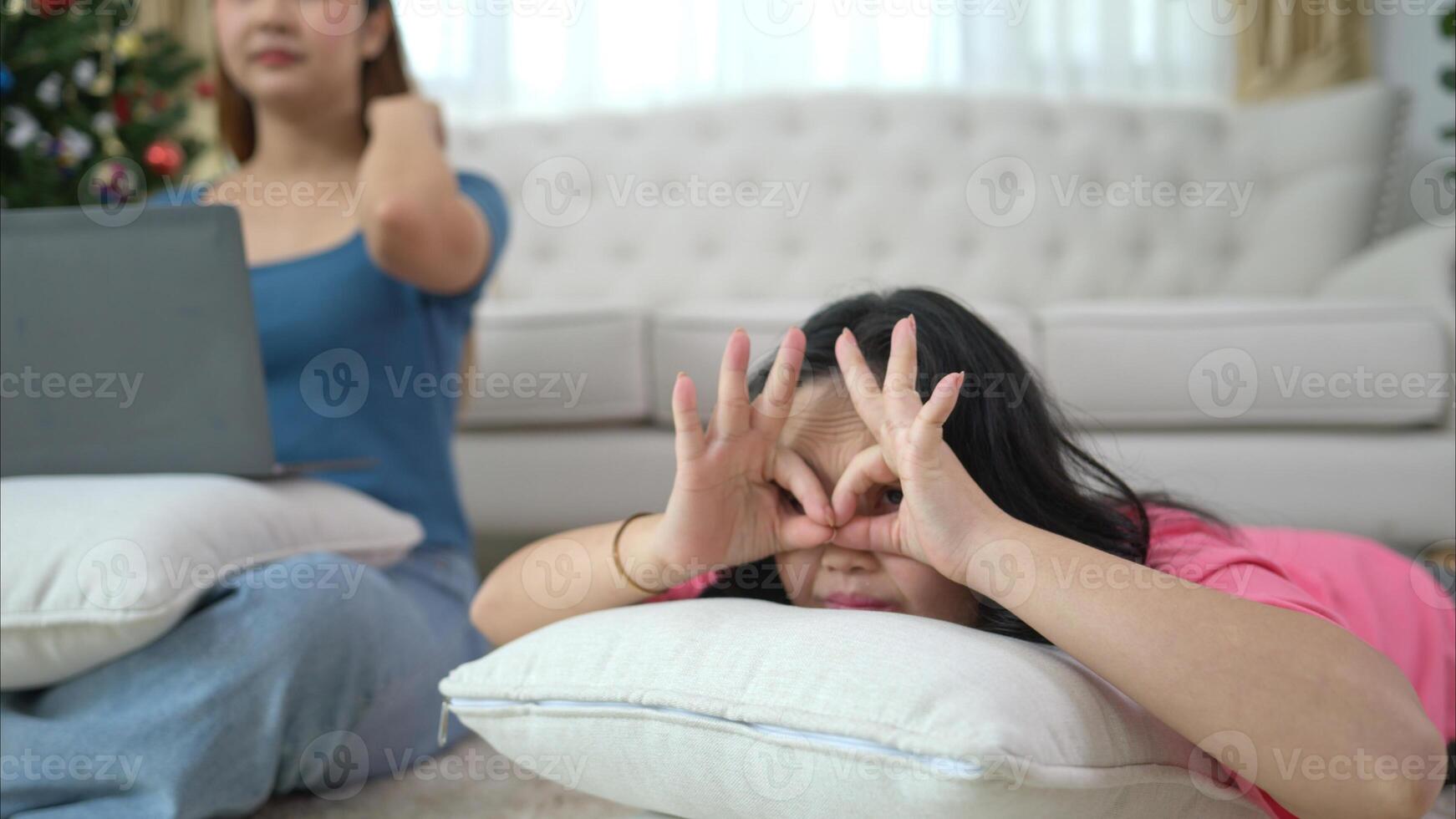Two sisters play online games and relax in the living room at home during the holidays. photo