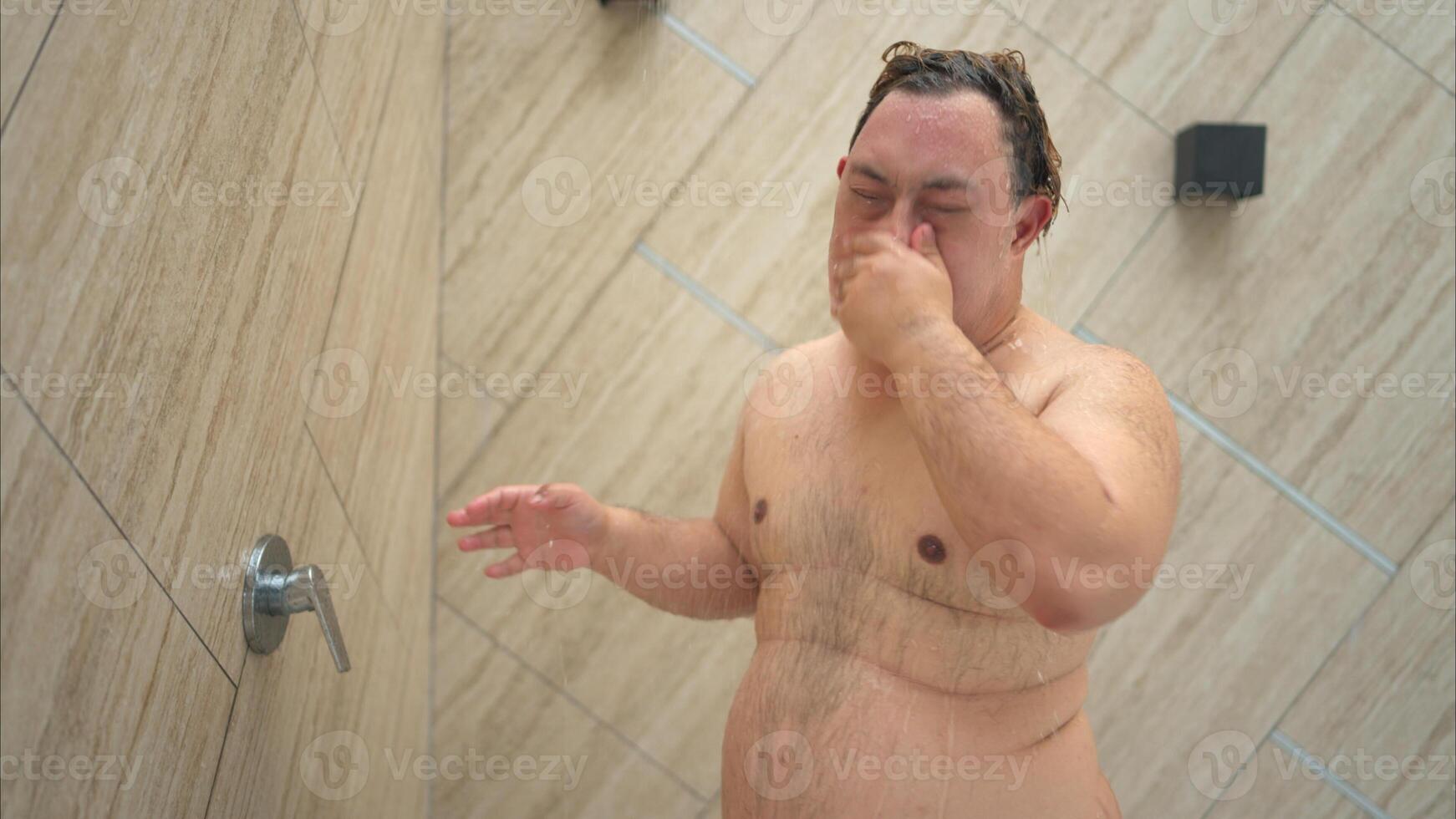 Young man gets wet before swimming in pool photo