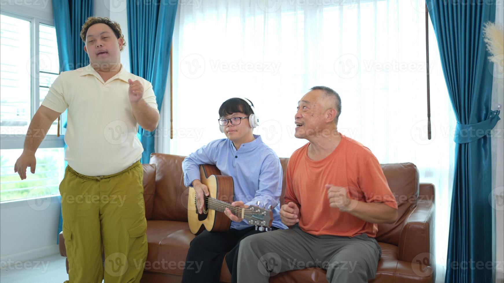 A family with an autistic child enjoys singing and dancing together at home during the holidays photo