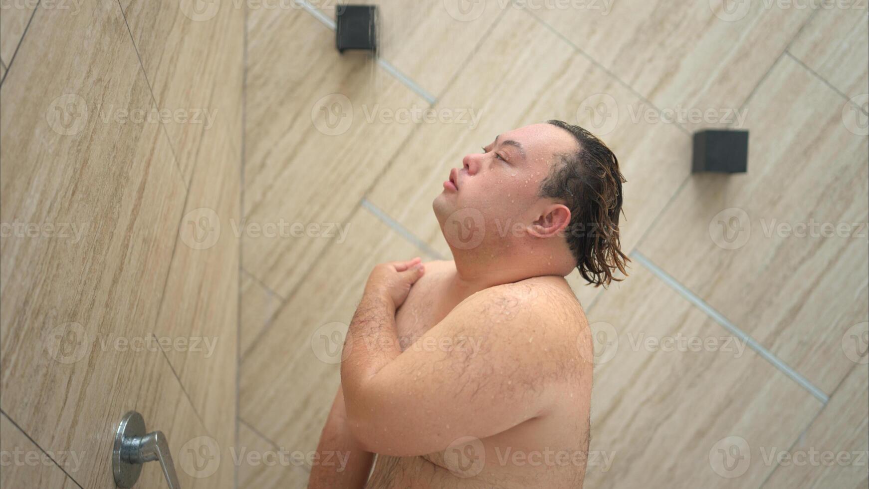 Young man gets wet before swimming in pool photo