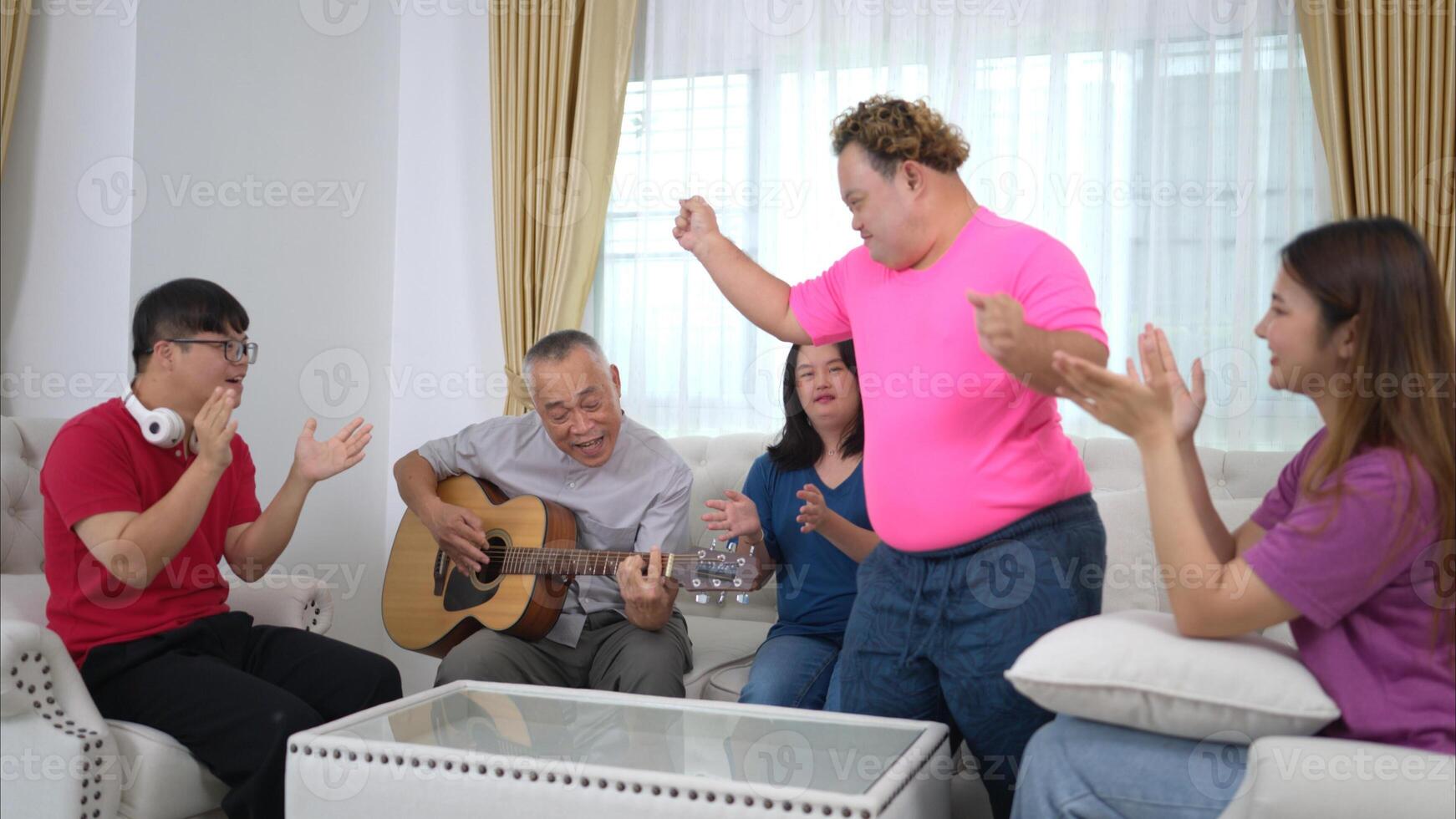 A grandfather with grandchild enjoys singing and dancing together at home during the holidays photo