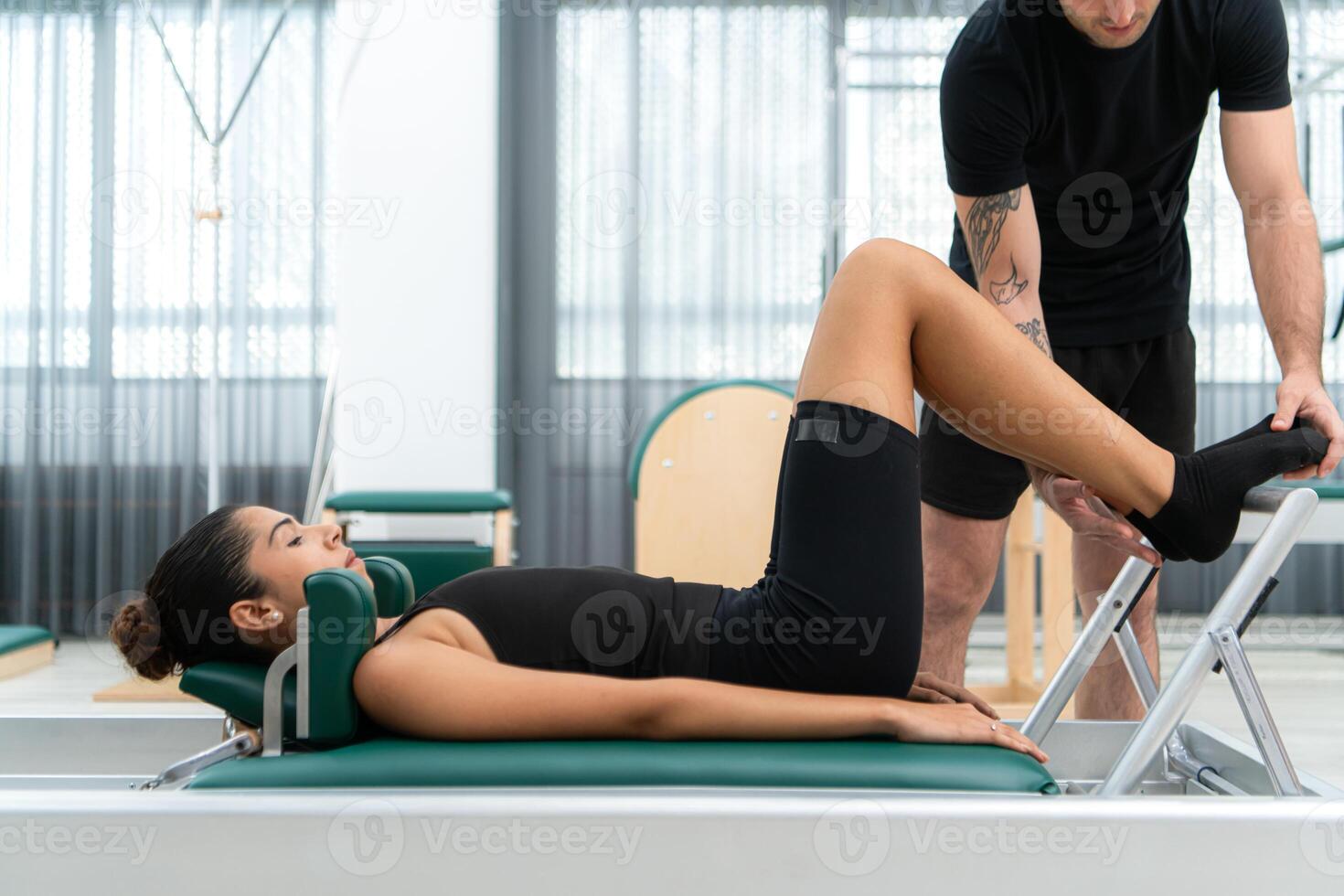 A young man and a young woman are doing pilates exercises on a pilates reformer photo