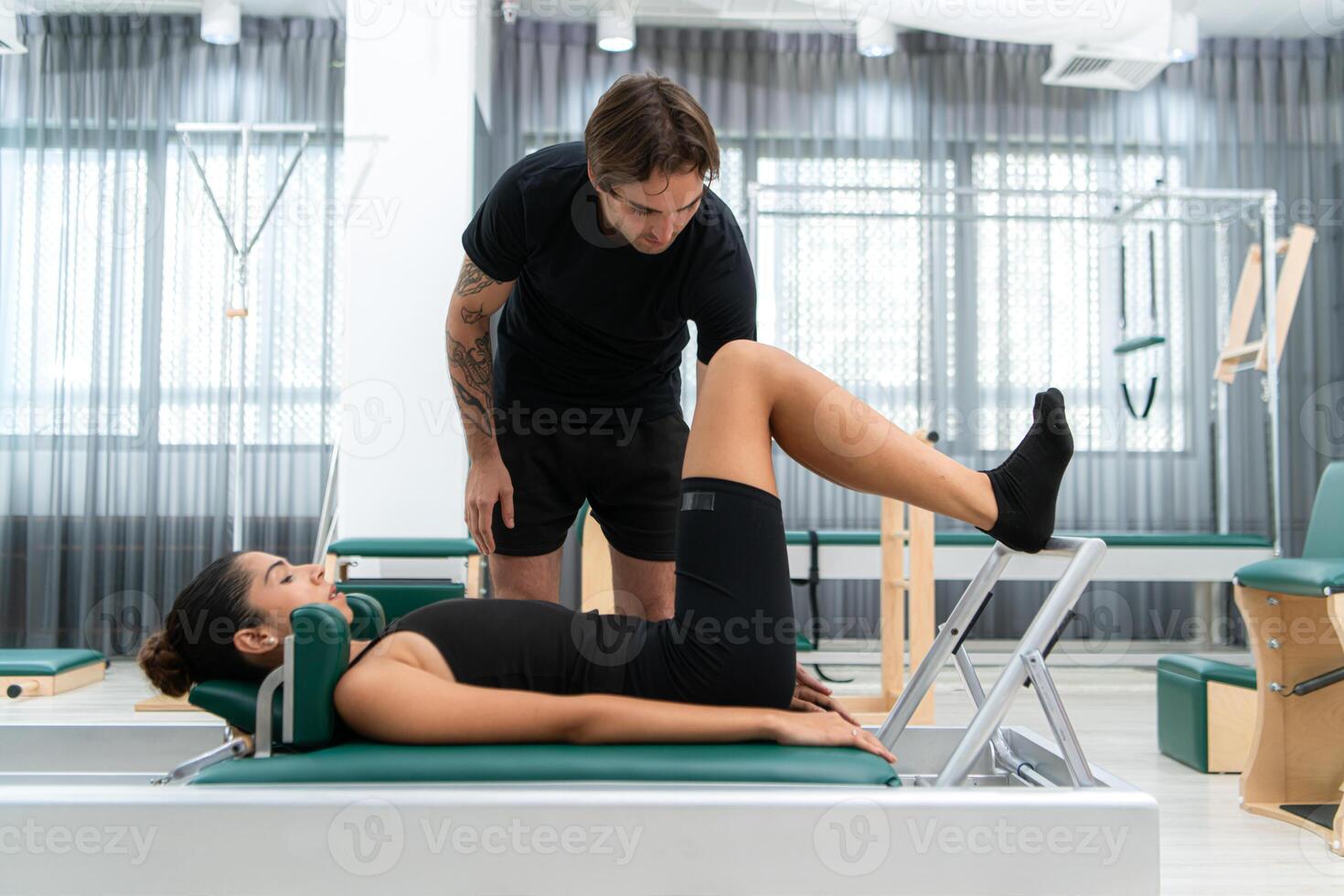 A young man and a young woman are doing pilates exercises on a pilates reformer photo