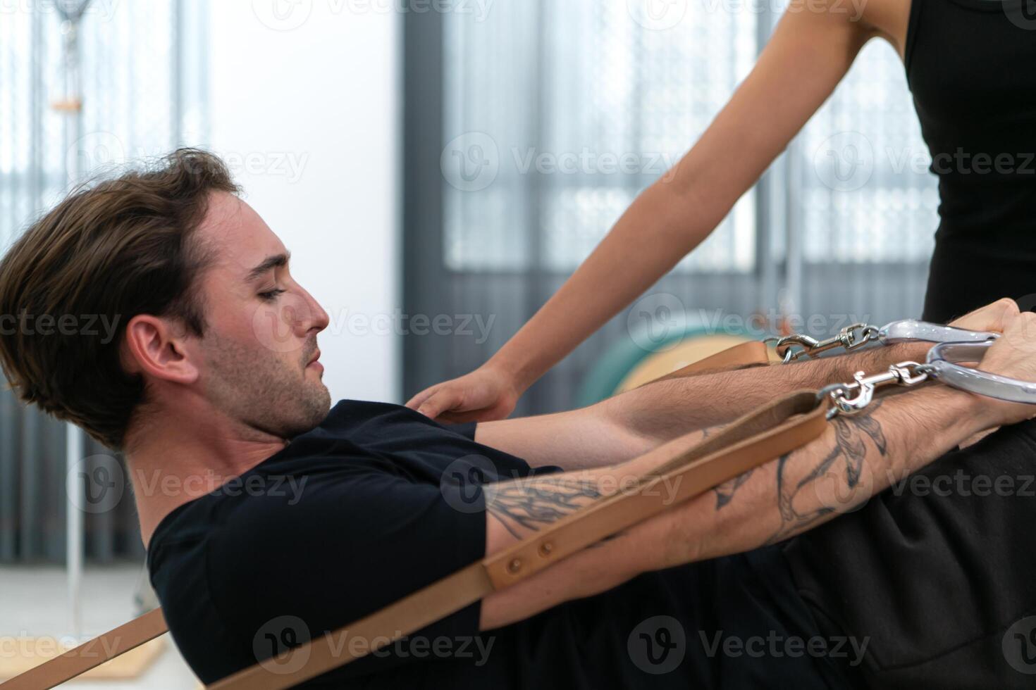 A young man and a young woman are doing pilates exercises on a pilates reformer photo