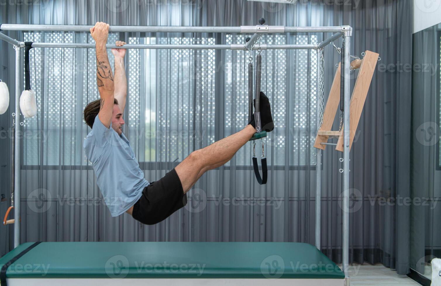 A young man doing pilates exercises on a pilates cadillac photo