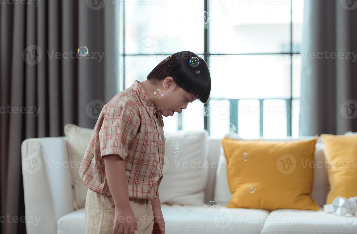 A special child having fun playing with a soap bubble bag in the living room of the house photo