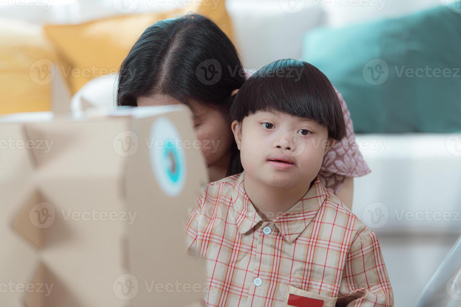 A special child and his mom having fun and relaxing on a holiday together in the living room of the house photo
