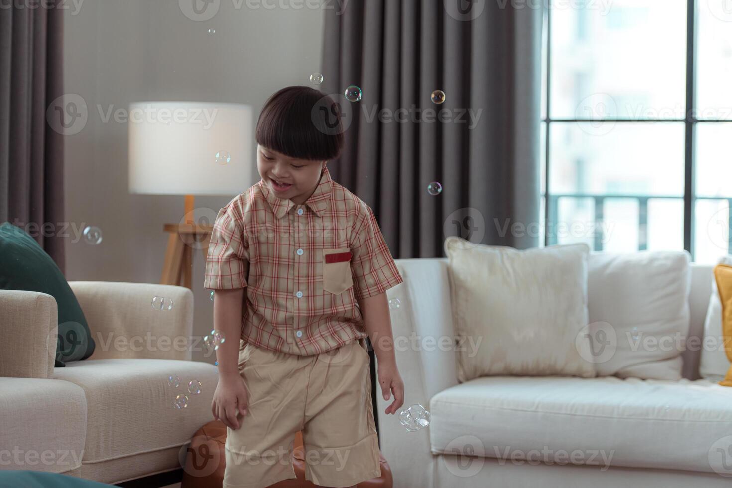 A special child having fun playing with a soap bubble bag in the living room of the house photo
