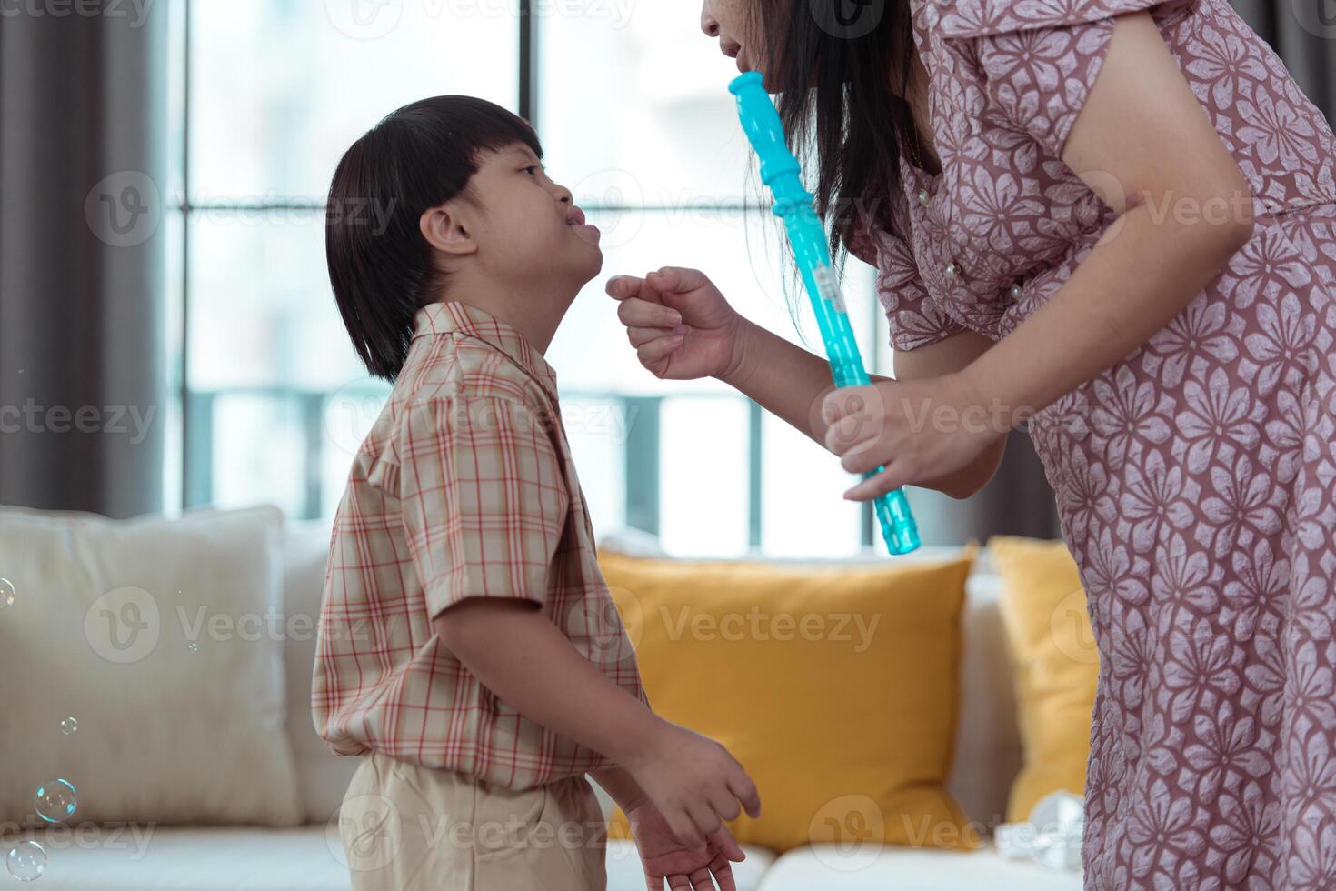 A special child having fun playing with a soap bubble bag in the living room of the house photo