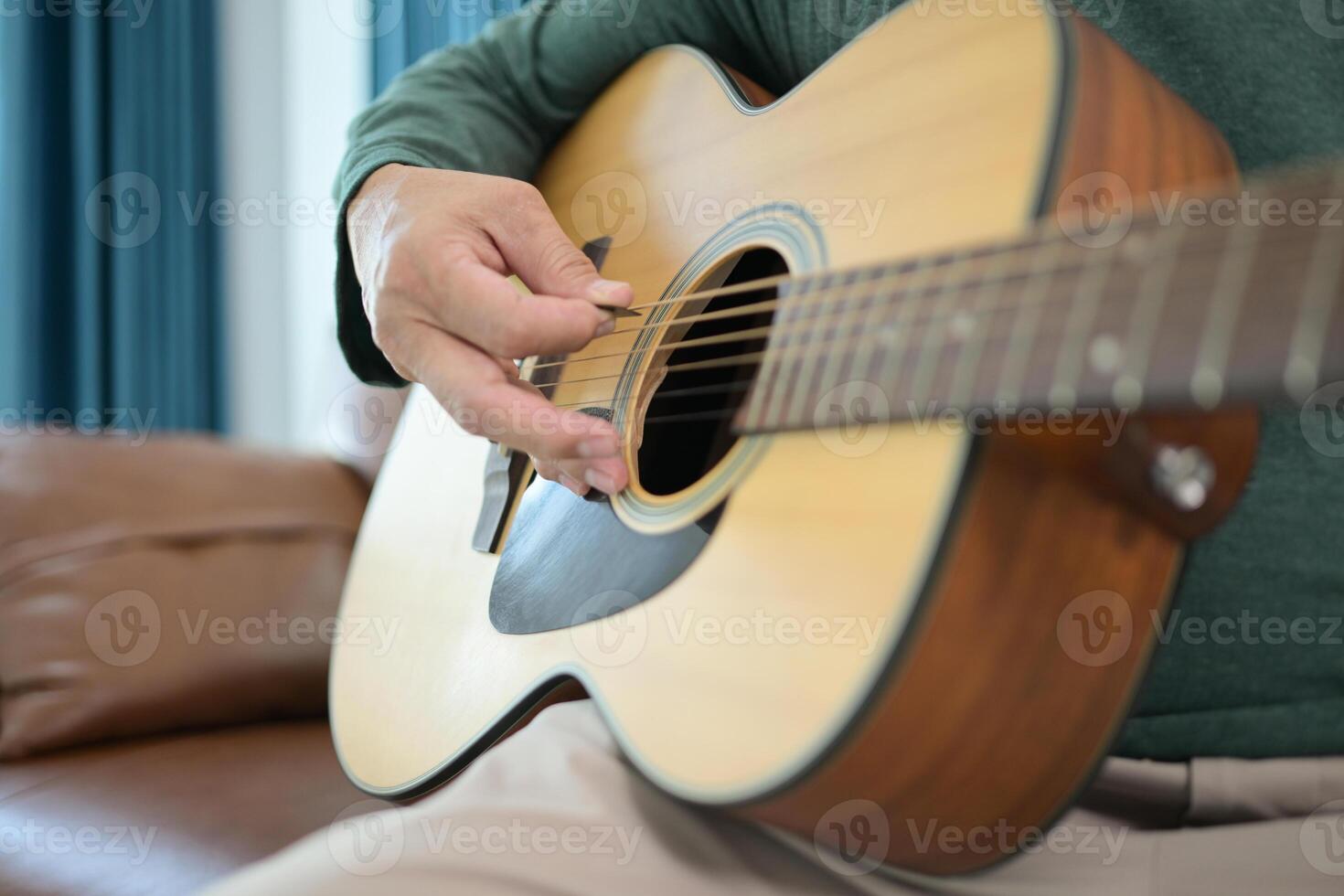 Senior man a veteran guitarist plays music at home photo