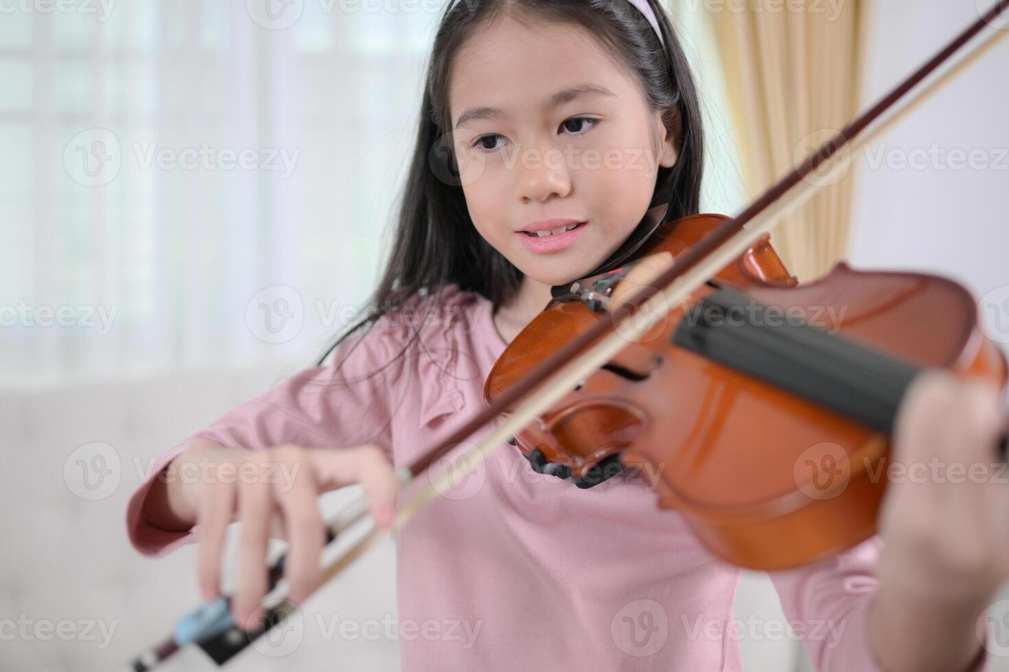 A girl violinist plays and practices the violin at home photo