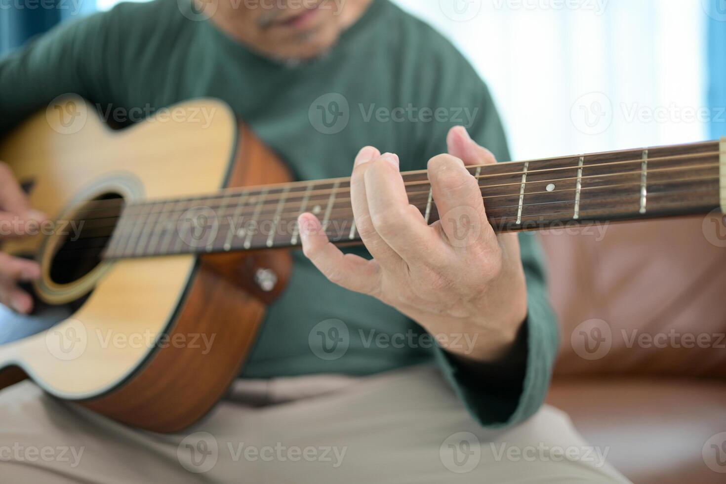 Senior man a veteran guitarist plays music at home photo