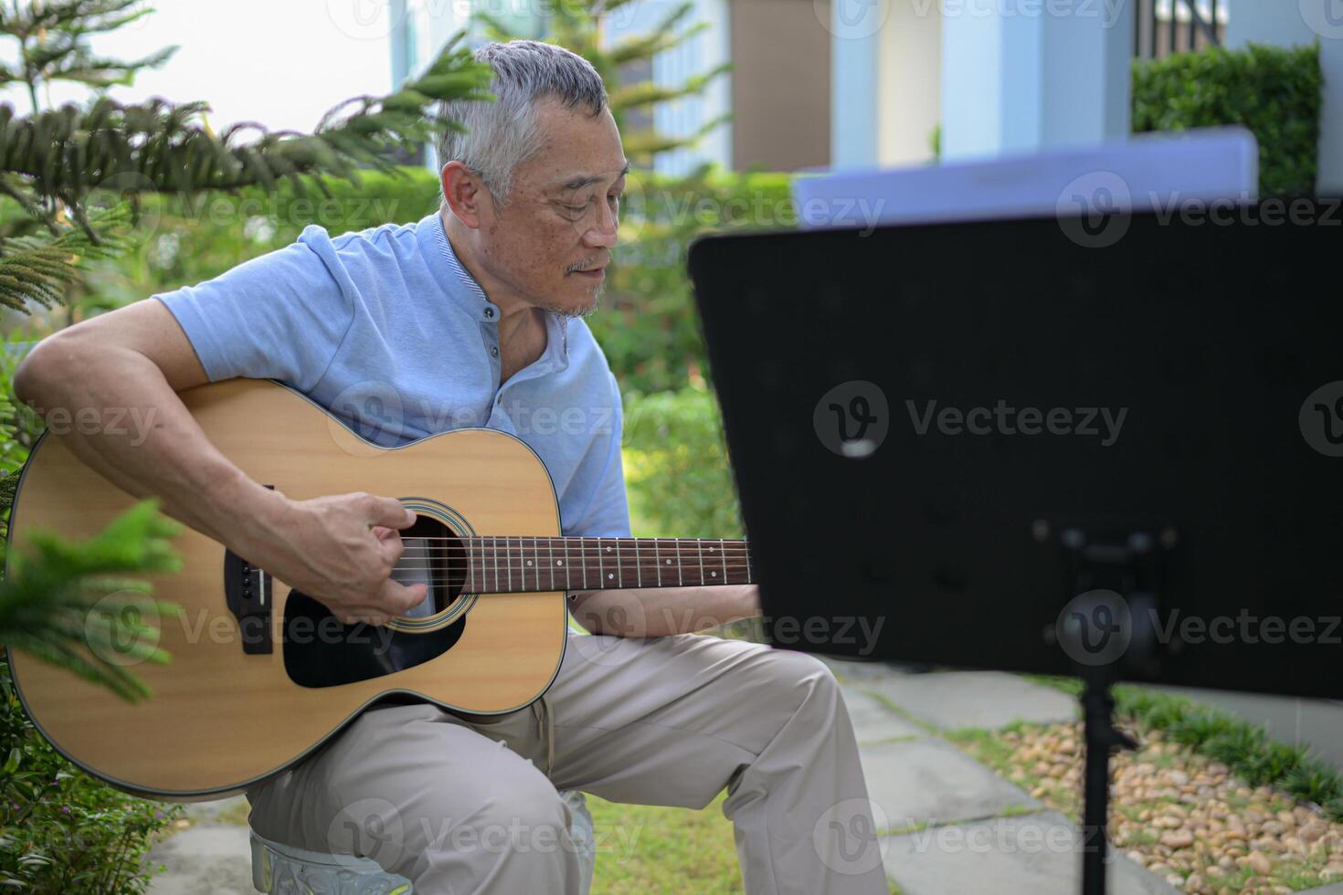 A girl violinist and her grandfather practice music together in the garden at home photo