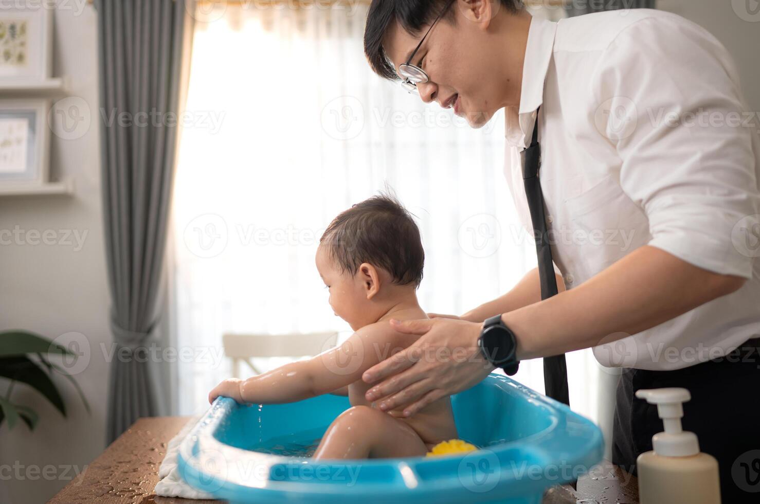 When dad gives the baby a bath, he enjoys it photo