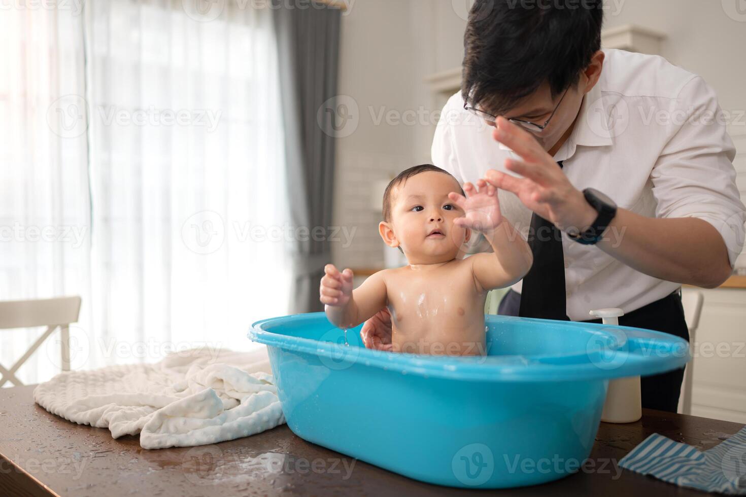 When dad gives the baby a bath, he enjoys it photo