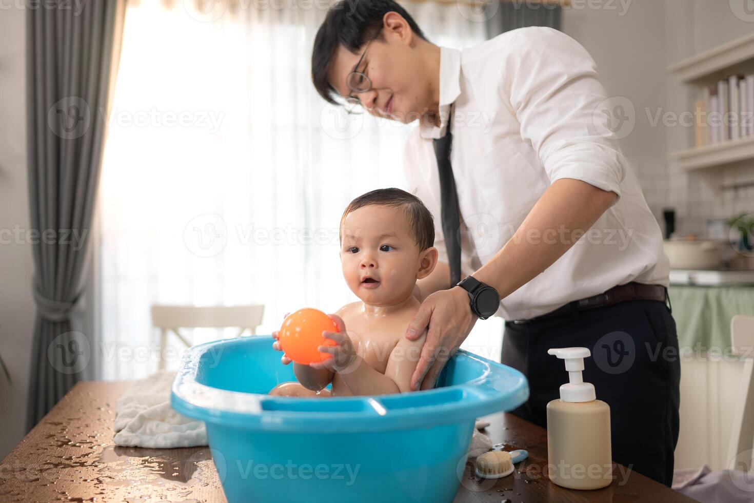 When dad gives the baby a bath, he enjoys it photo