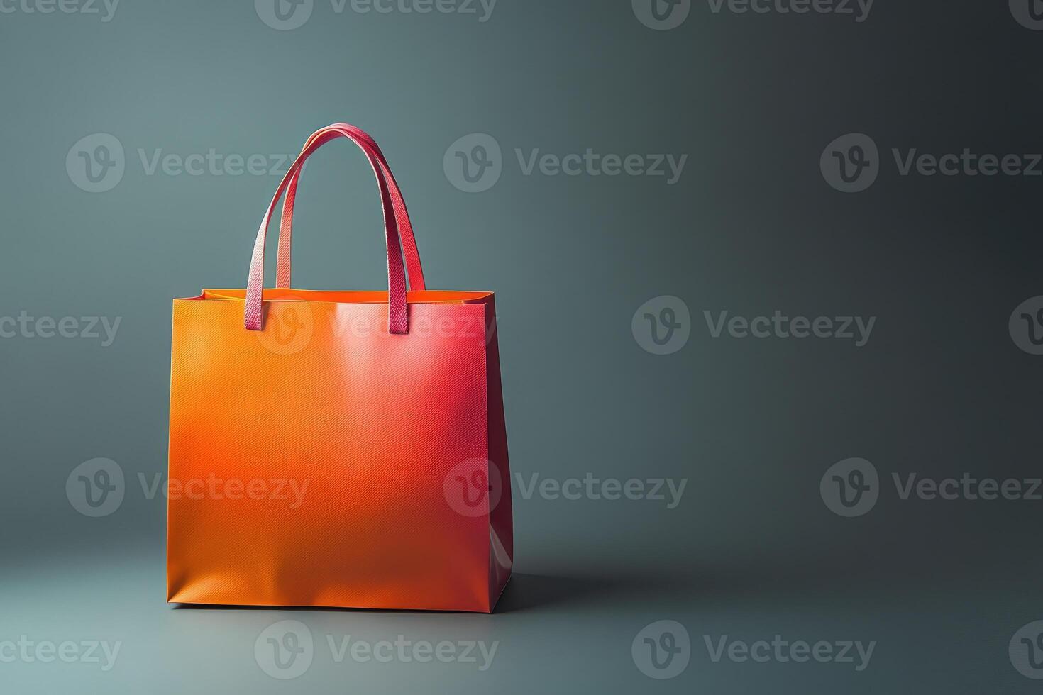 Orange Shopping Bag with Pink Handles on Grey Background photo
