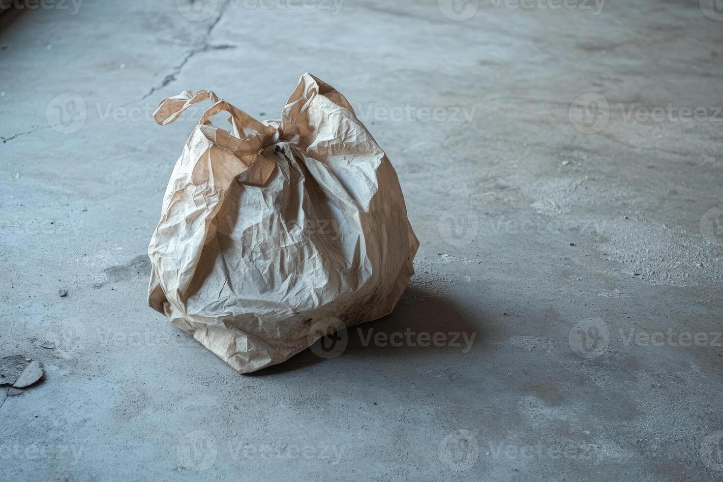 A Crumpled Paper Bag on a Concrete Floor photo
