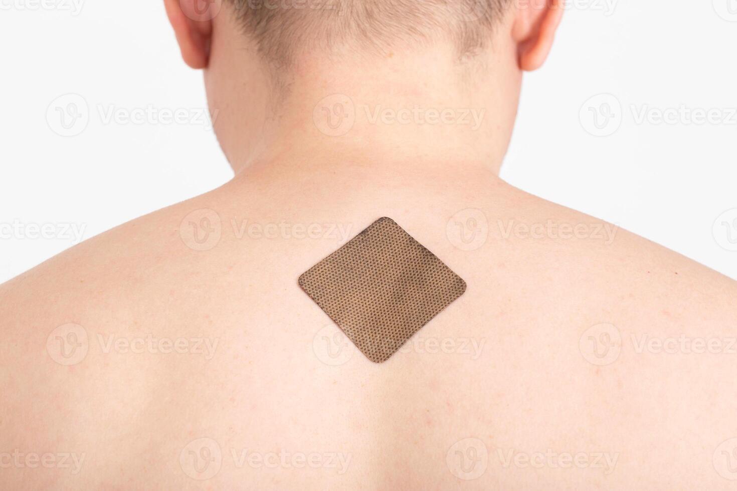 The guy with the anti-tobacco medical plaster on the skin of the body to get rid of the bad habit of smoking, a dose of nicotine, healthy photo
