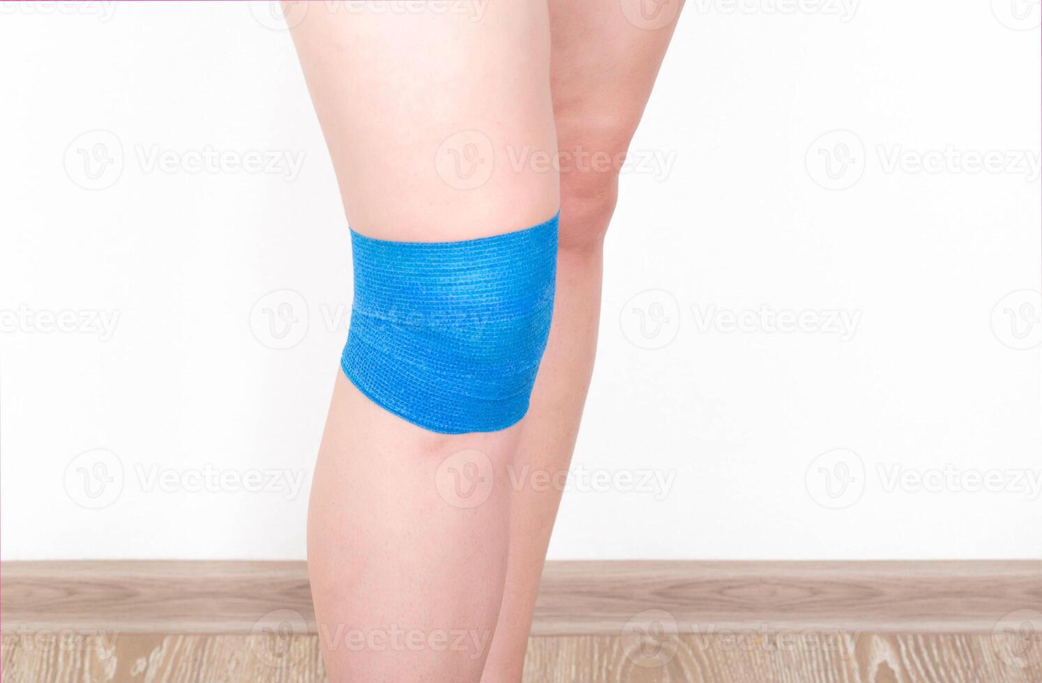 Fixation of a sore knee joint with an elastic bandage for arthrosis and sports injury. photo
