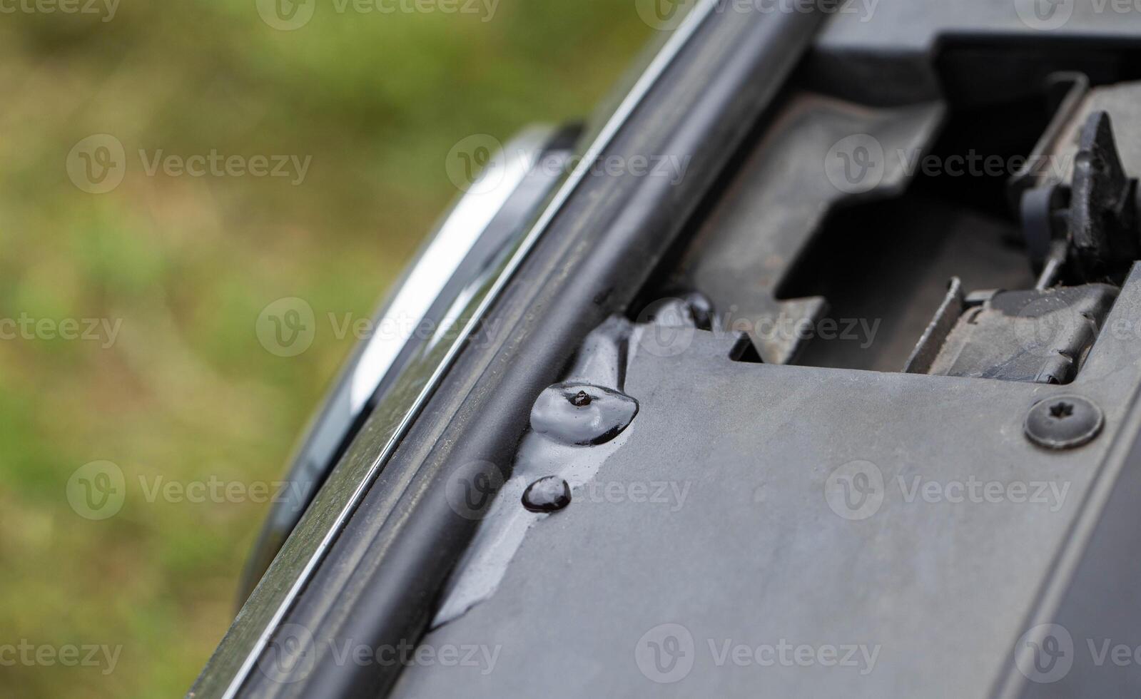 A leak of technical fluid in the engine compartment of the car. Car malfunction concept. Leakage, copy space for text photo