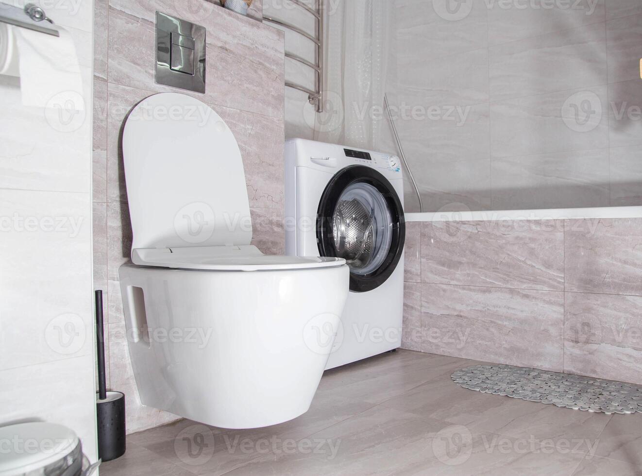 Modern renovation in the bathroom combined with a toilet. Hanging toilet and washing machine. Copy space for text photo