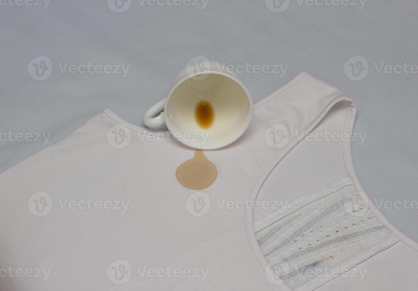Spilled coffee cup on white shirt, coffee stain on clothes, close-up, cup, stain remover photo