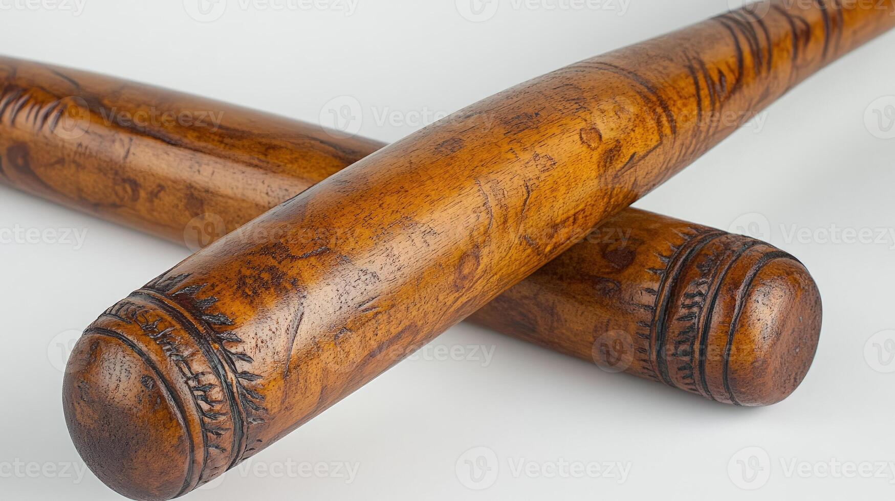 Two beautifully crafted wooden bats lie crossed on a white surface, highlighting their design photo
