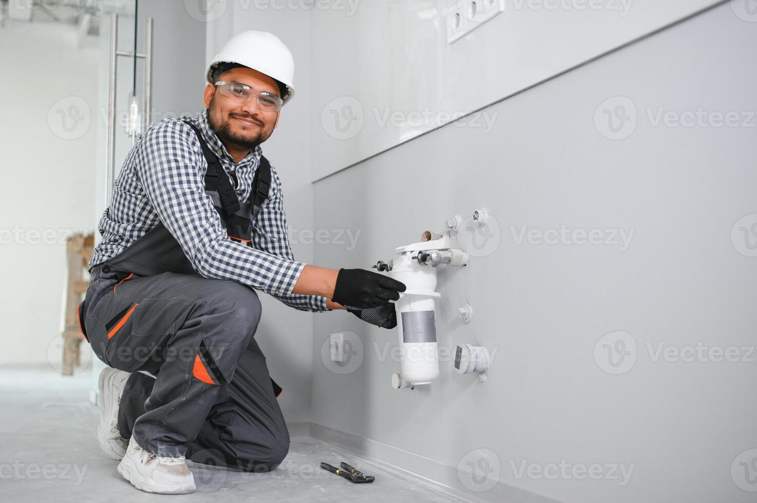 plumber installing water equipment - meter, filter and pressure reducer photo