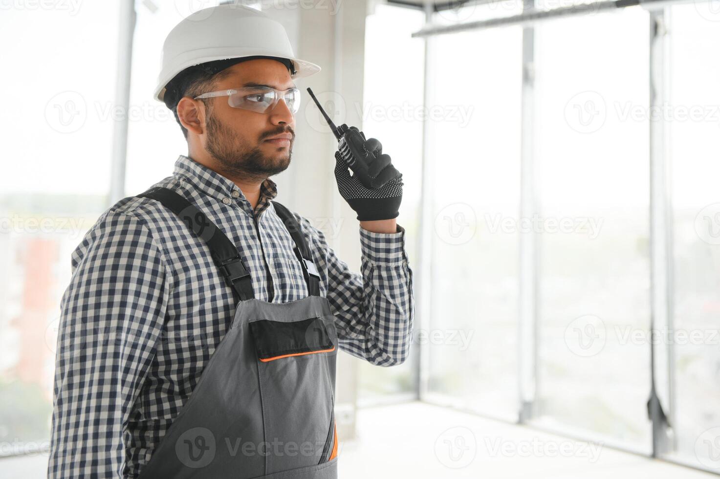 male builder in hardhat with walkie talkie or radio photo