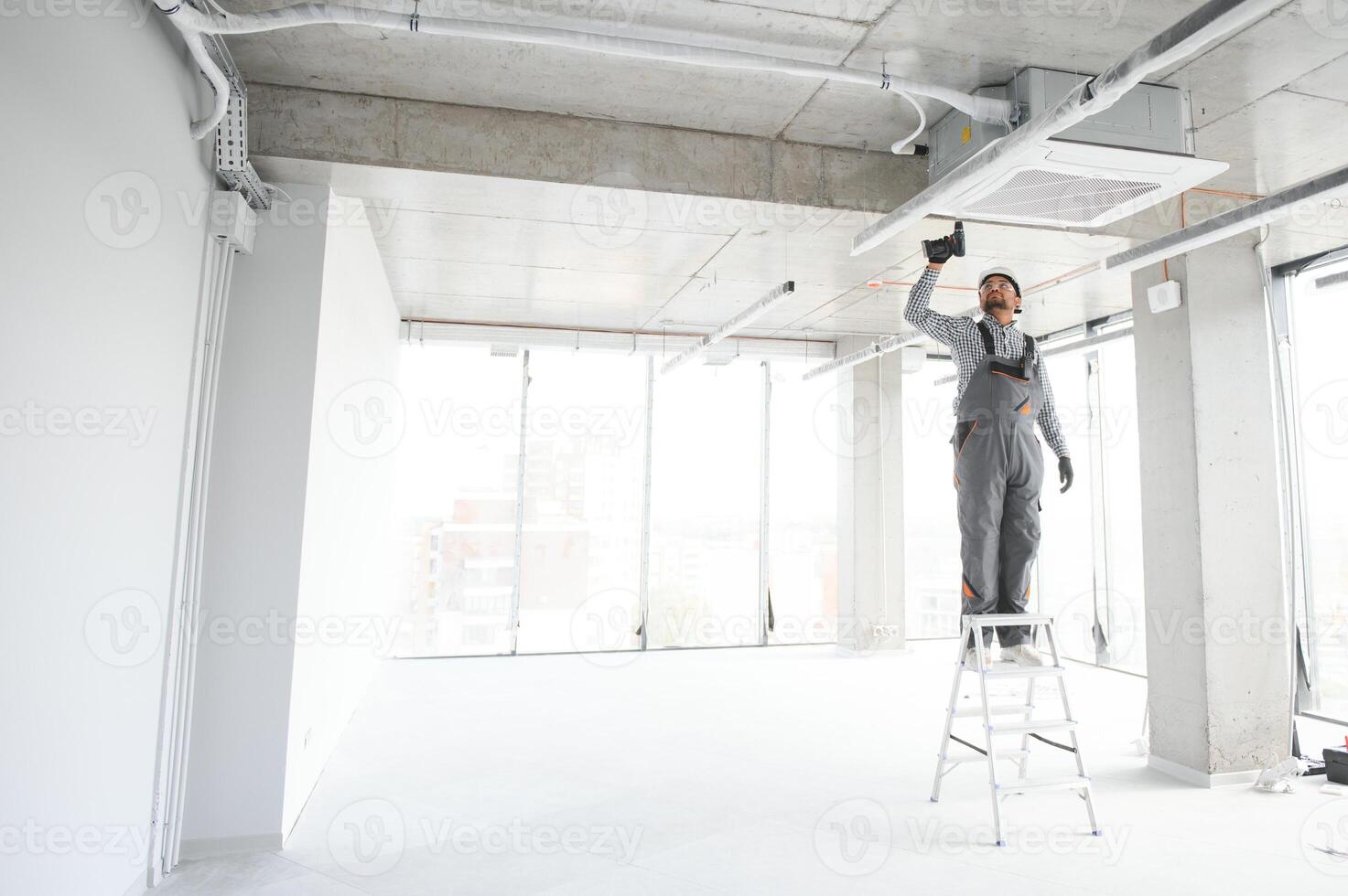 Professional technician maintaining modern air conditioner indoors. Space for text photo