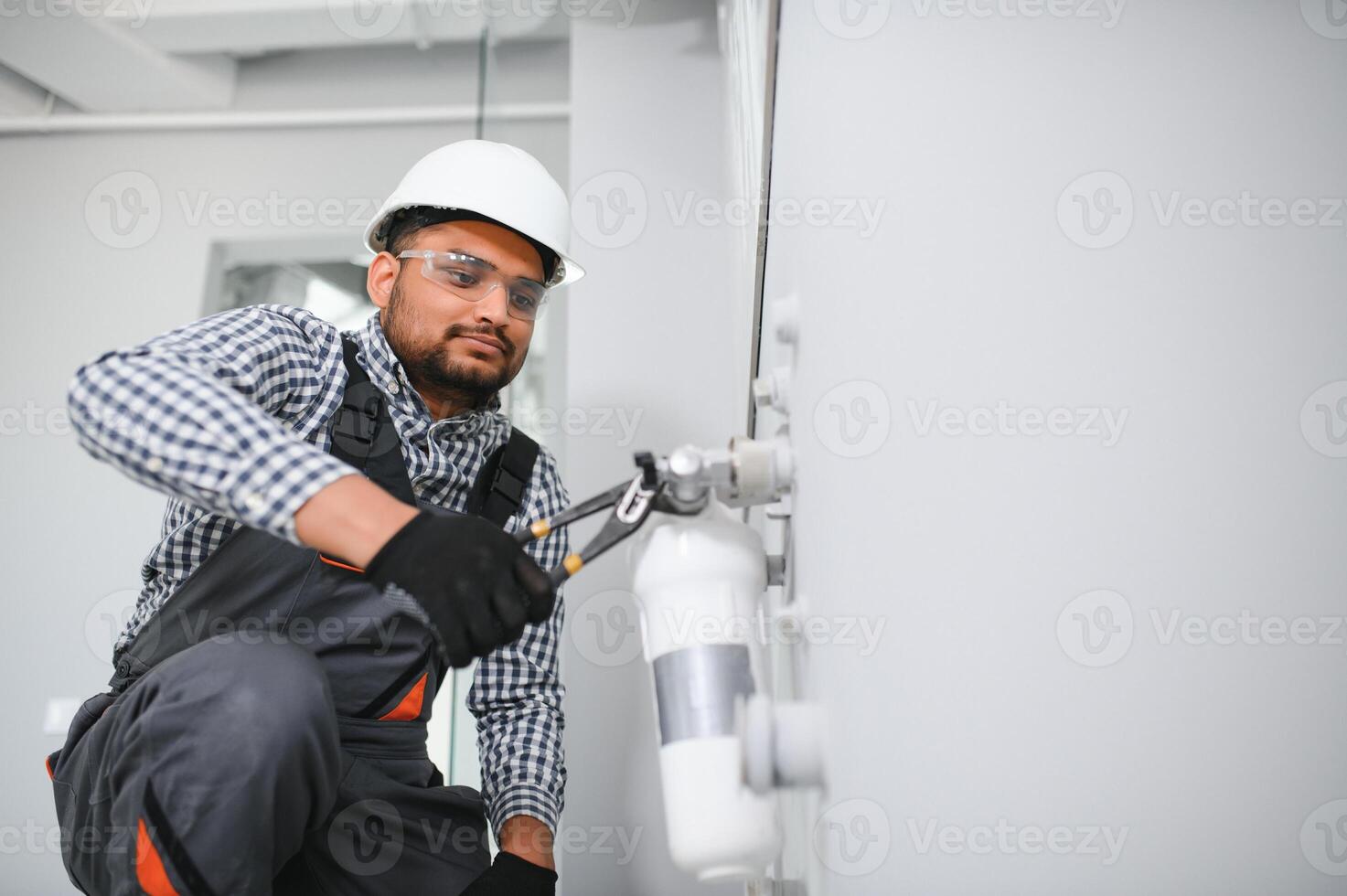 plumber installing water equipment - meter, filter and pressure reducer photo