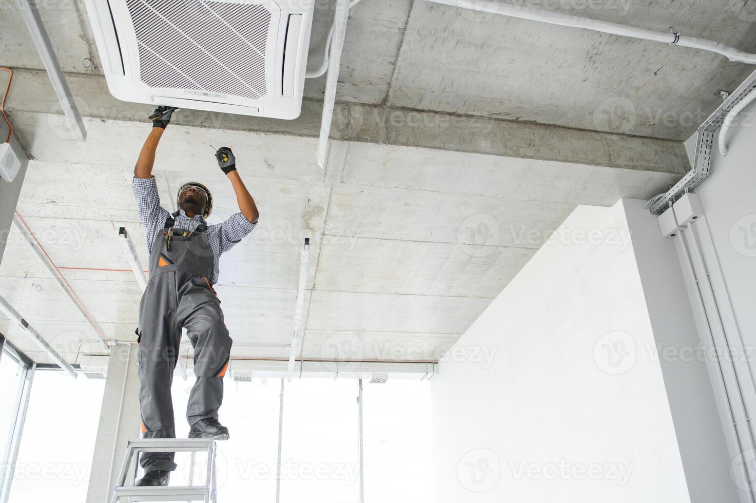 Professional repairman installing air conditioner in a room photo
