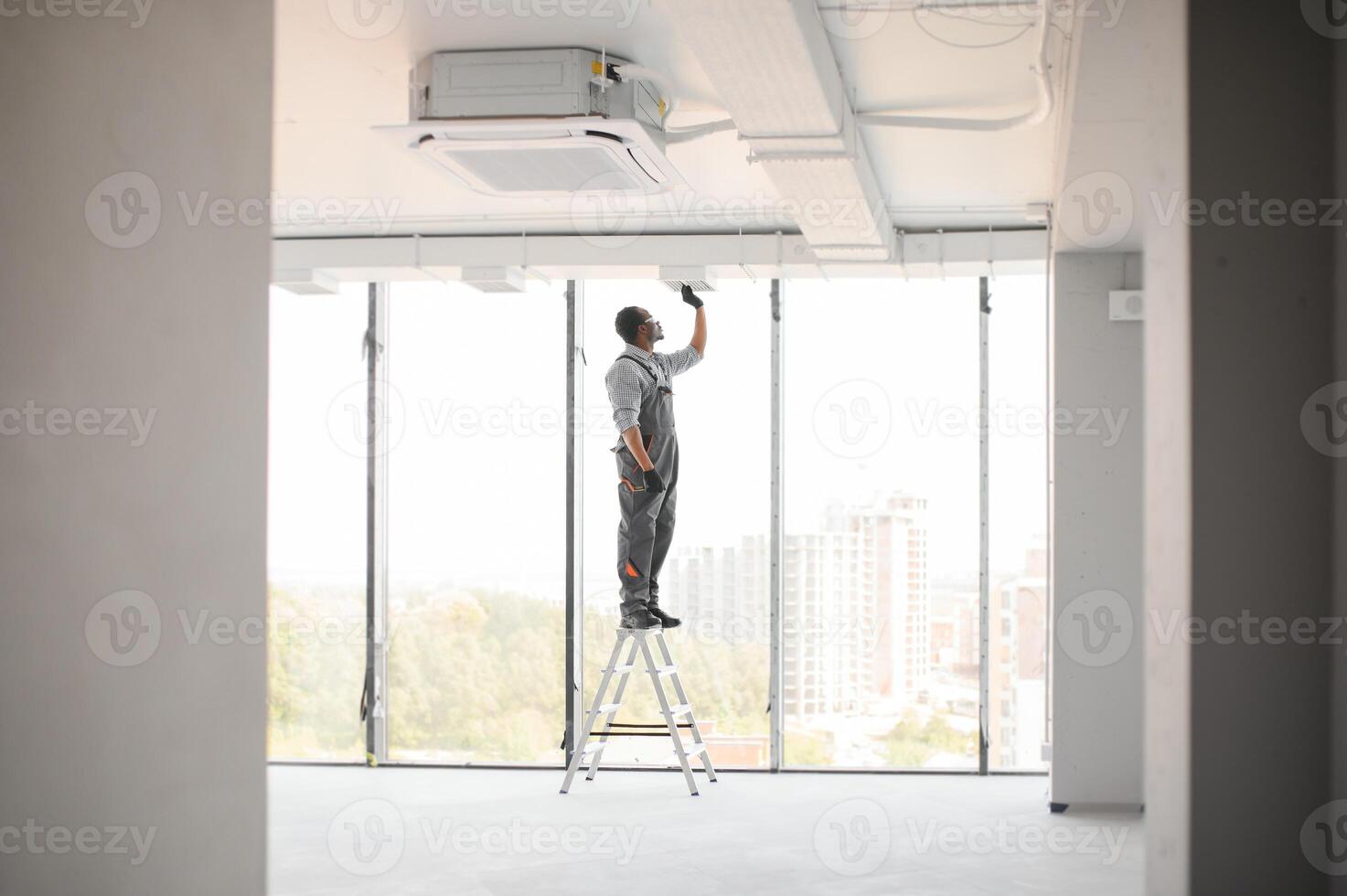 Industrial Theme. Warehouse Heating and Cooling System Installation by Professional Caucasian Technician. Commercial Building Ventilation Rectangle Canals. Air Distribution photo
