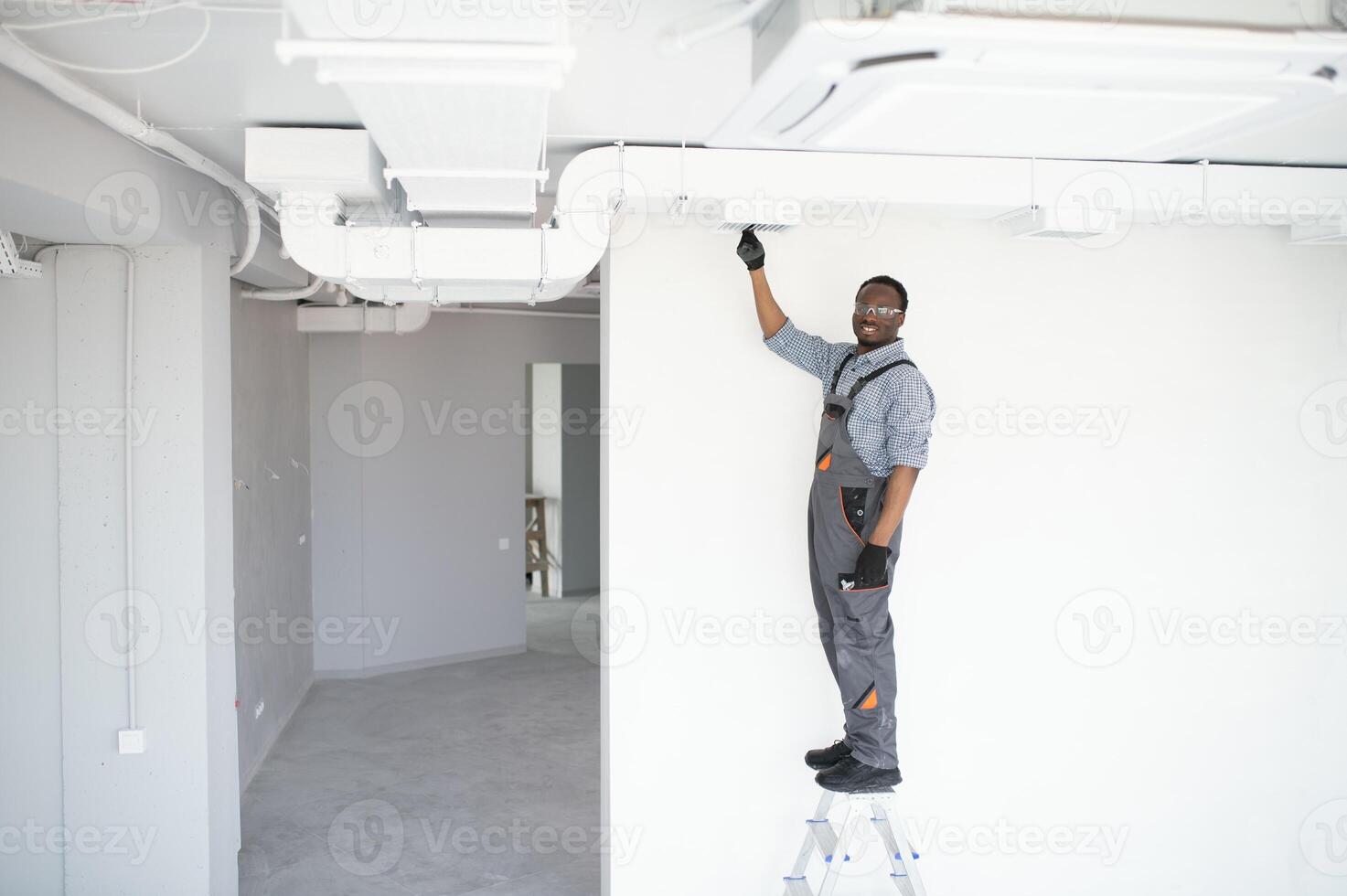hvac worker install ducted pipe system for ventilation and air conditioning. copy space photo
