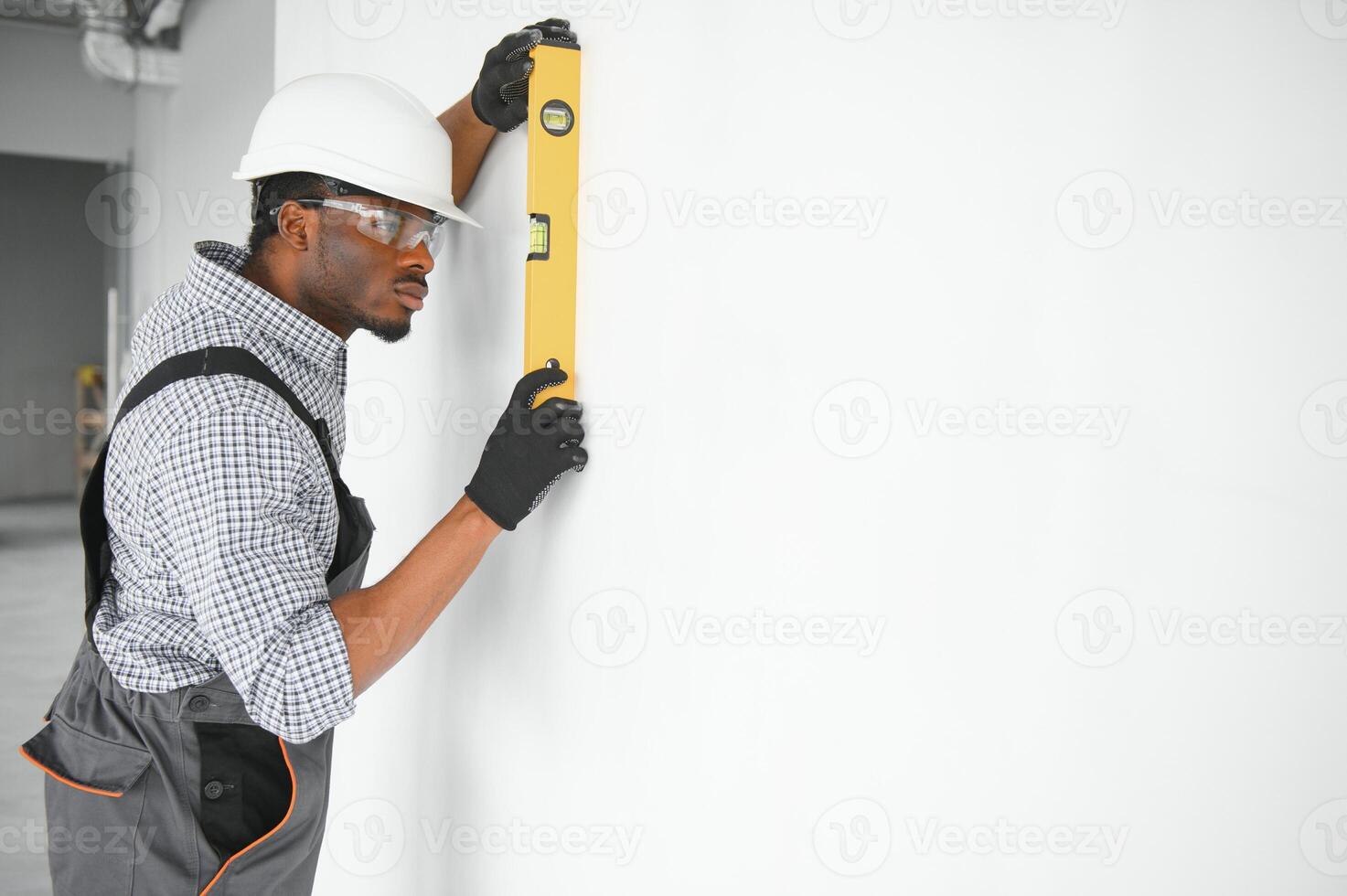Construction worker observing and surveying wall alignment using water level photo