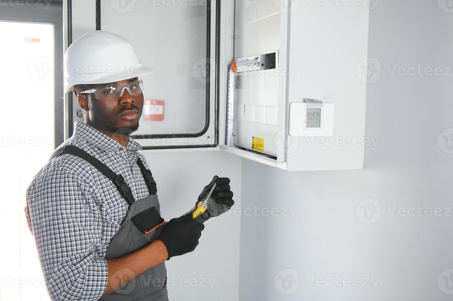 A male electrician works in a switchboard photo