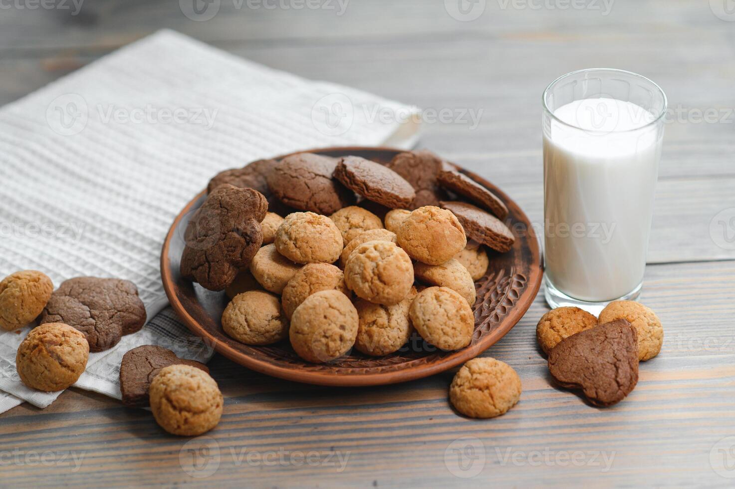 Yummy homemade freshly baked cookies with chocolate chips served with glass of milk on table photo