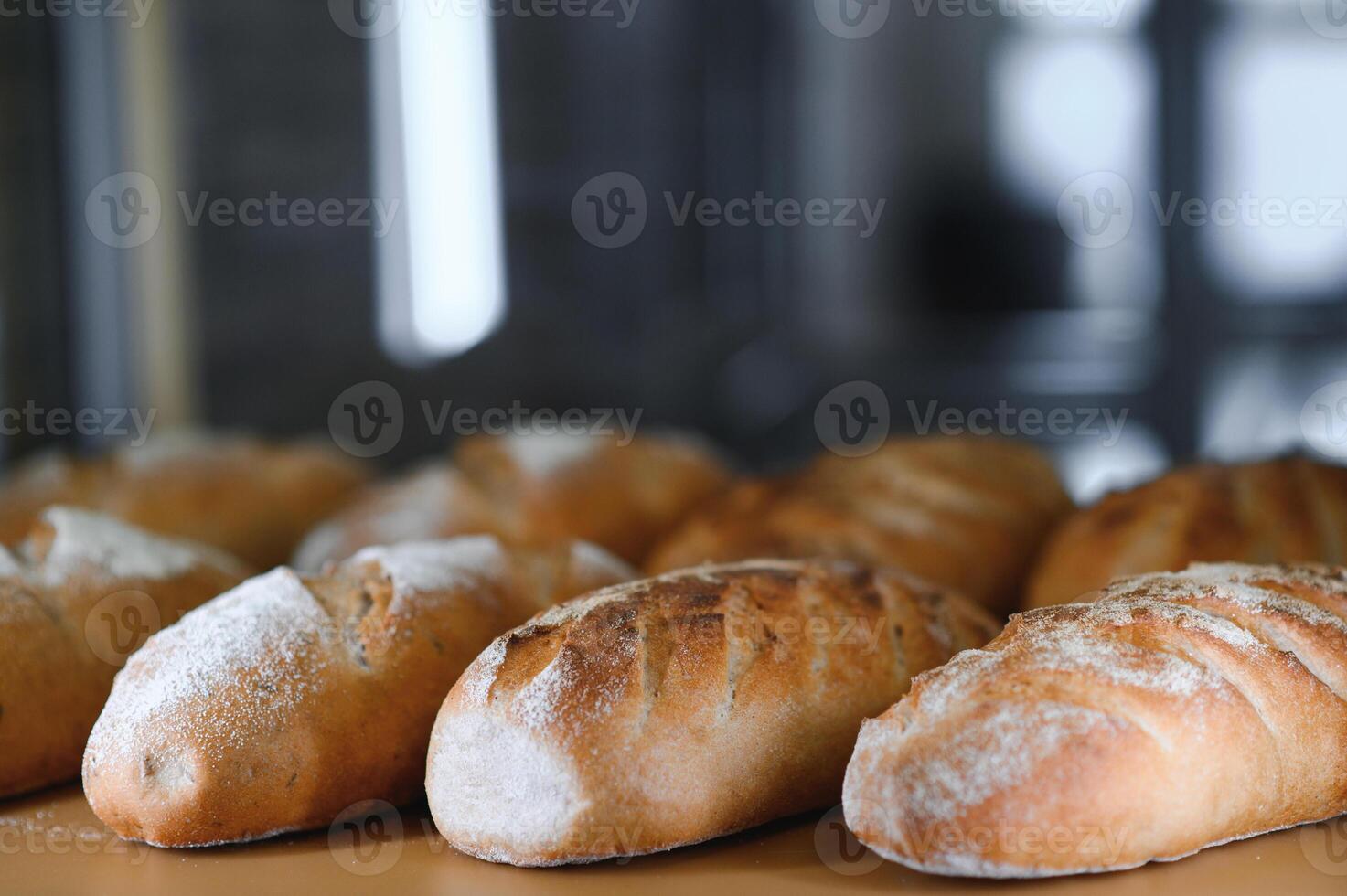 Freshly baked bread on bakery shelves. Bread diversity in bright light. Breads with a golden crust on wooden shelves photo