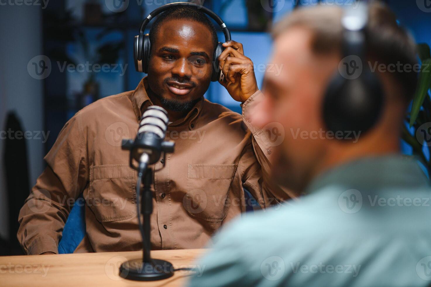 Man recording podcast using high tech microphones to interview guest, ensuring flawless and sound quality for audience photo