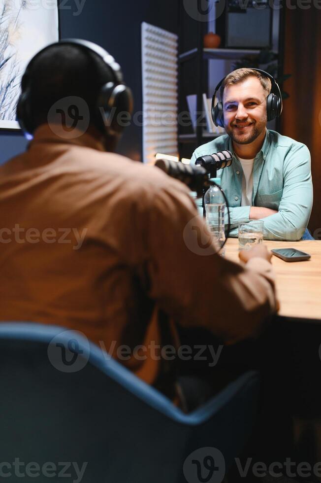 Man recording podcast using high tech microphones to interview guest, ensuring flawless and sound quality for audience photo