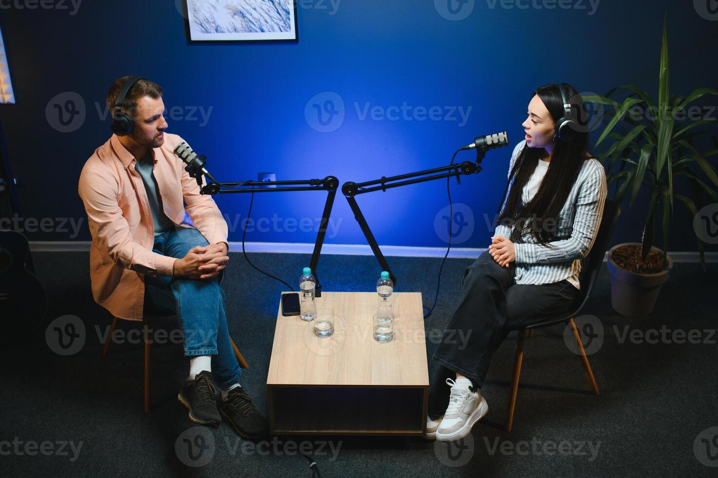 Show host interviewing woman during live stream, talking about fashion and style trends, disagreeing with her opinions. Man arguing with social media celebrity, recording podcast photo