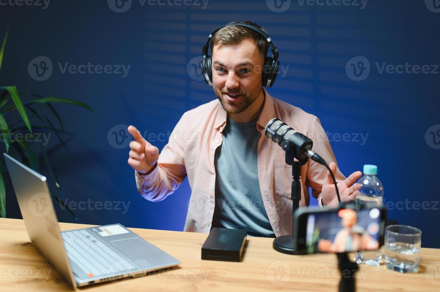 A blogger records content in his studio. The host of the blog is a young man who is very enthusiastic about telling his subscribers a story photo