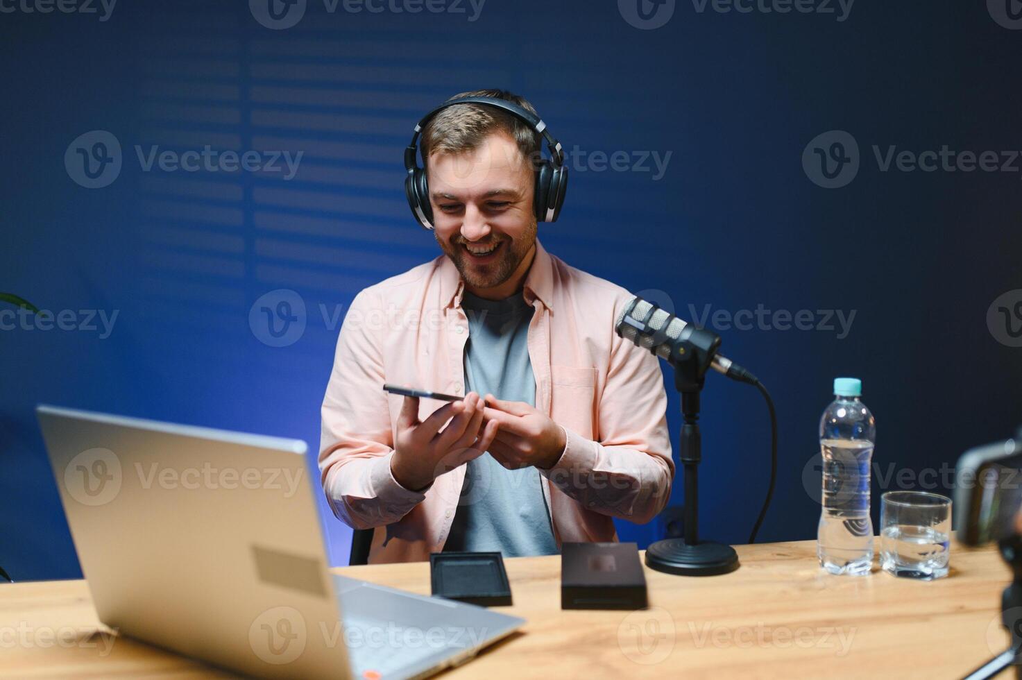 Joyful young man recording unboxing in studio photo