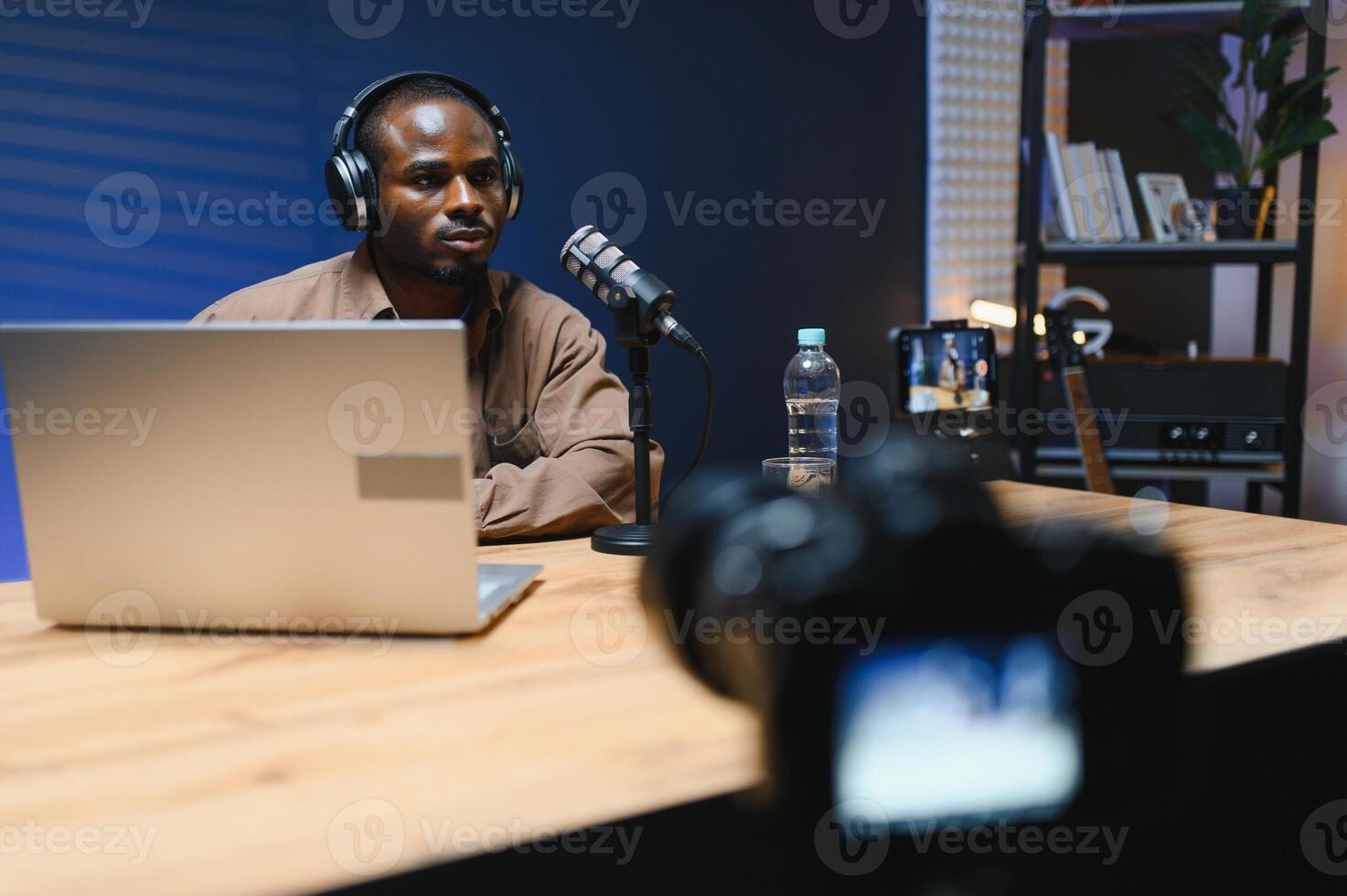 Young african american male vlogger recording blog in studio with professional microphone. photo