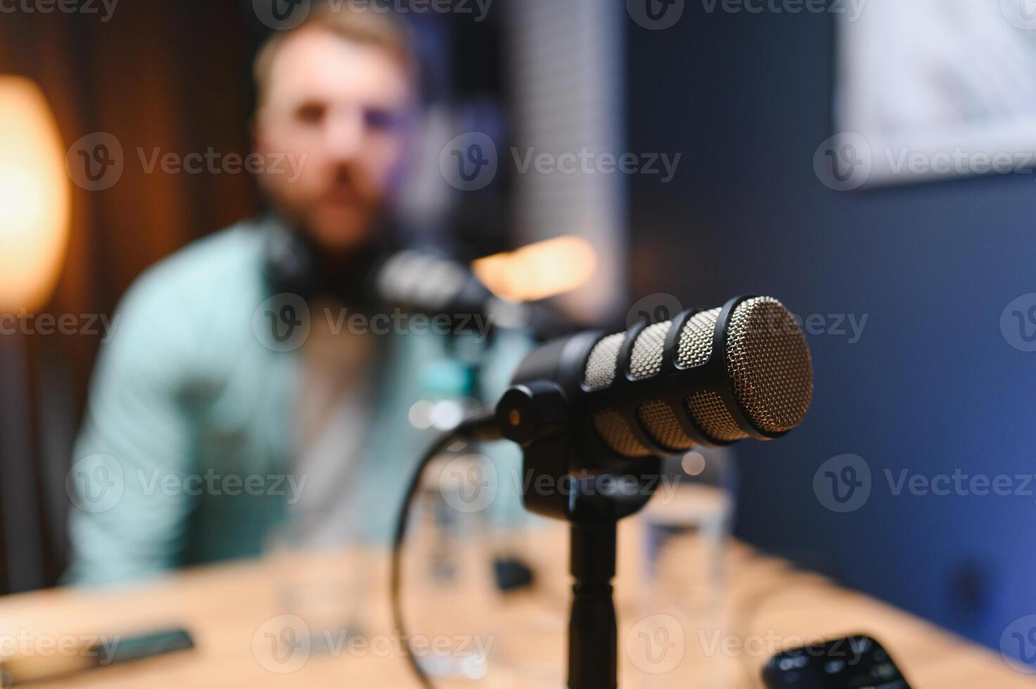 Focus on professional microphone and podcast host in background photo