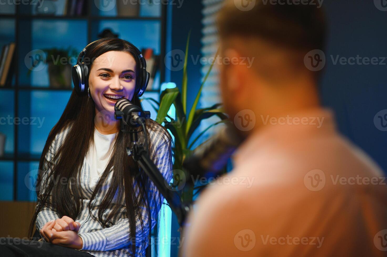 Side view of successful woman hosting podcast interviewing man while recording with professional microphones, copy space photo