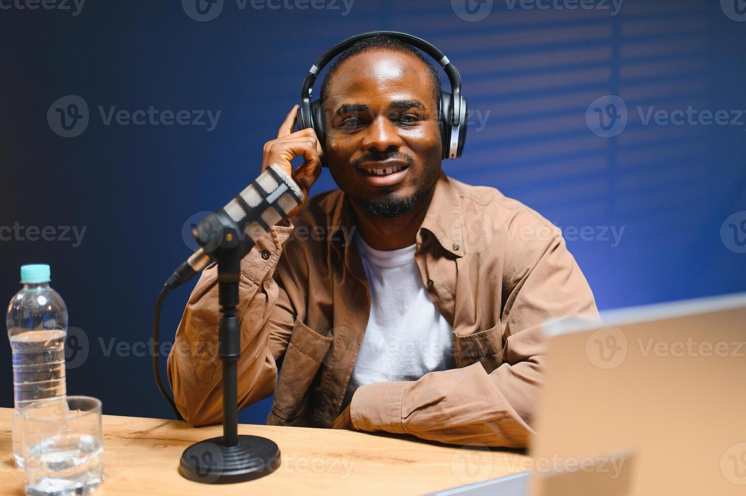 Young African American male vlogger influencer in headphones record blog on smartphone photo