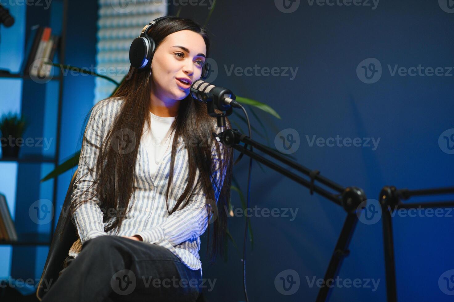 Female podcaster in headphones interviewing man guest using microphone, smiling, recording and broadcasting audio podcast in studio. Content creator, blogging photo
